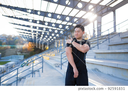 The athlete was injured, the Asian man has a shoulder pain after training and running The athlete was injured, the Asian man has a shoulder pain after training and running 92591831