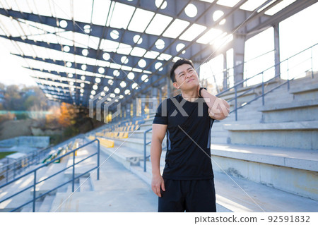 The athlete was injured, an Asian man has a sore neck after training and running 92591832