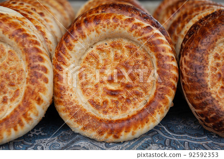 Typical traditional flatbread with crunchy crust with sesam just baked Typical traditional flatbread with crunchy crust with sesam just baked 92592353