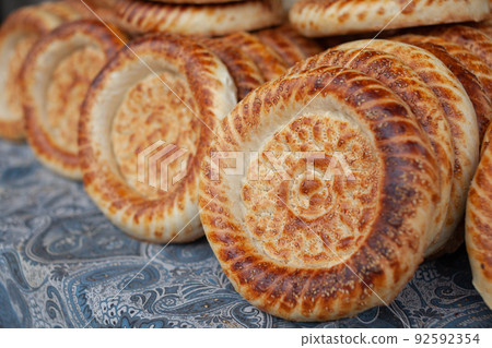 Typical traditional flatbread with crunchy crust with sesam just baked Typical traditional flatbread with crunchy crust with sesam just baked 92592354