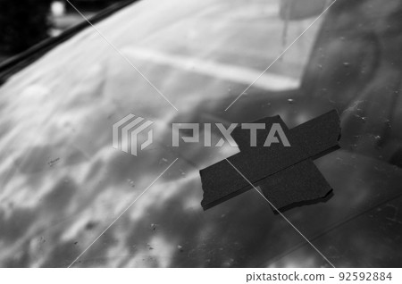 Tape covering a chip on a car windshield. Tape covering a chip on a car windshield. 92592884
