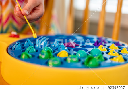 Children's game of using a miniature pole and line lowered into open plastic fish to catch them as the pond spins.  92592937