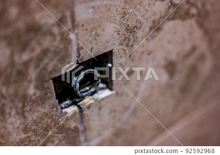 Cut-out section in bathroom shower tile with pipe connection protruding for water hookup.  92592968