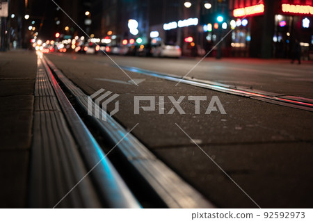 Street level selective focus on trolley rail lines at night in San Diego. 92592973