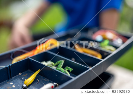 Selective focus on lure inside an open fishing tackle box. Selective focus on lure inside an open fishing tackle box. 92592980