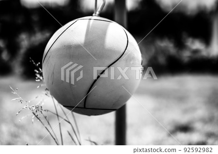 Tetherball sitting idle next to the pole in a backyard. Tetherball sitting idle next to the pole in a backyard. 92592982