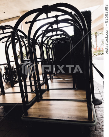 Group of hotel luggage carts at the entrance for guests checking in. Group of hotel luggage carts at the entrance for guests checking in. 92592998
