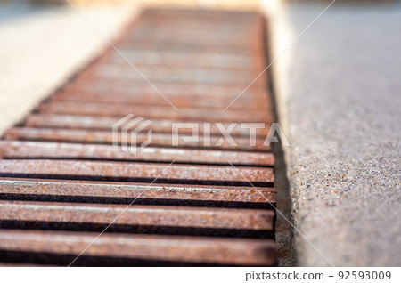 Grate over a stormwater trench in a concrete slab.  92593009