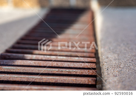 Grate over a stormwater trench in a concrete slab.  92593016