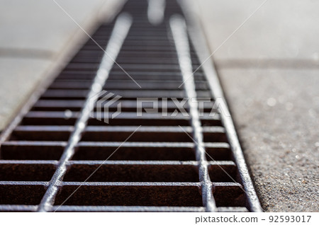Grate over a stormwater trench in a concrete slab.  92593017