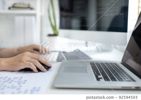 Professional development programmers are sit on a desk with work equipment such as: computer-laptop-tablet. for working in programming or writing code on  website,  HTML, javascript, Software. 92594503