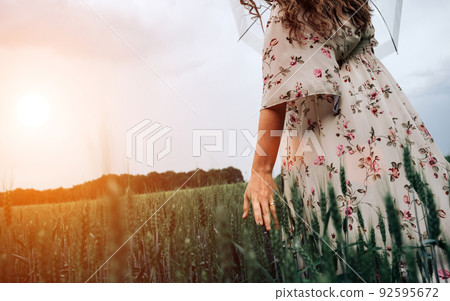Hand wheat field. Young woman on cereal field touching ripe wheat spikelets by hand in sunset. Nature, summer holidays, agriculture concept. Hand wheat field. Young woman on cereal field touching ripe wheat spikelets by hand in sunset. Nature, summer holidays, agriculture concept. 92595672