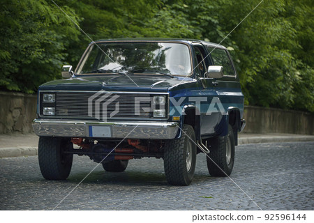 Old retro car with its owner and unknown passenger Old retro car with its owner and unknown passenger 92596144