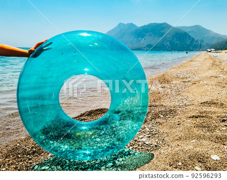 Blue inflatable swim ring float and sunglasses on the beach. Blue inflatable swim ring float and sunglasses on the beach. 92596293