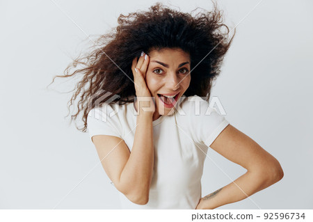 HUGE SALE OFFER. Happy excited pensive Latin female with waving afro hair, hold hand on face, say Yeah, looking at camera, stay isolated on white background. Copy space, free place, fashion banner HUGE SALE OFFER. Happy excited pensive Latin female with waving afro hair, hold hand on face, say Yeah, looking at camera, stay isolated on white background. Copy space, free place, fashion banner 92596734