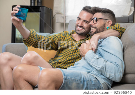 Young smiling gay couple taking selfie at home. 92596840