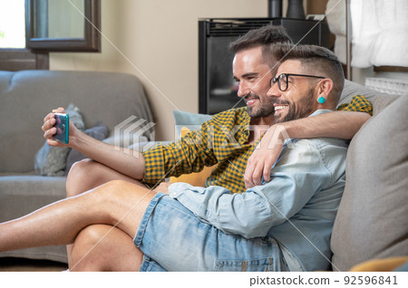 Young smiling gay couple taking selfie at home. 92596841