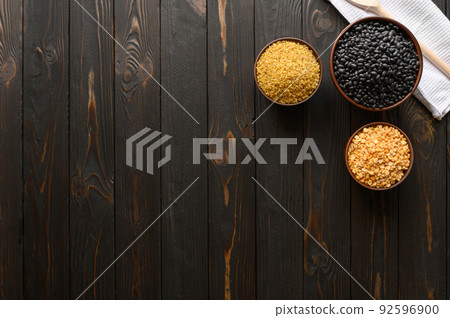 Different type of composition of raw dry legumes and cereals. Black beans, bulgur, peas. Different type of composition of raw dry legumes and cereals. Black beans, bulgur, peas. 92596900