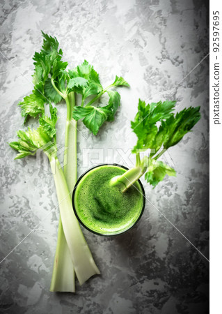 Celery fresh green juice in glass on grey background Celery fresh green juice in glass on grey background 92597695