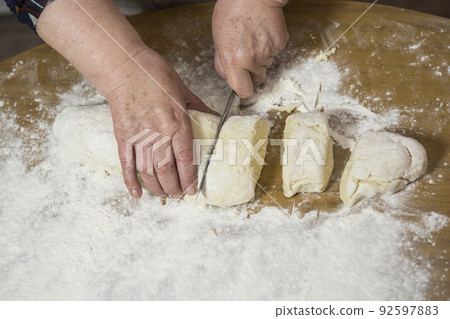 Hands kneading dough for gnocchi. Hands kneading dough for gnocchi. 92597883
