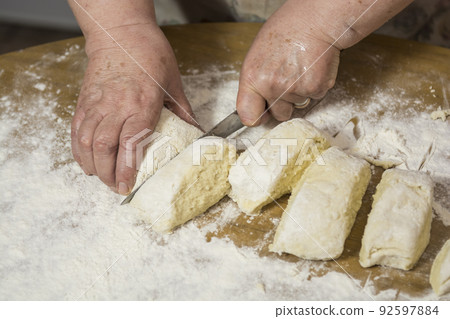 Hands kneading dough for gnocchi. Hands kneading dough for gnocchi. 92597884