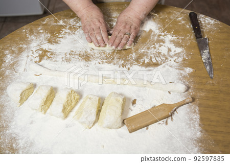 Hands kneading dough for gnocchi. Hands kneading dough for gnocchi. 92597885