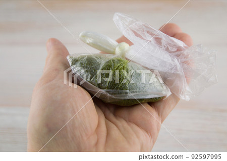 carcinogenic chewing tobacco (nas, nasvay, dip, snus) from Tajikistan, in a sealed bag in the man's hand, side view carcinogenic chewing tobacco (nas, nasvay, dip, snus) from Tajikistan, in a sealed bag in the man's hand, side view 92597995