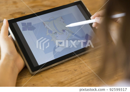 Woman drawing a picture on a tablet 92599317