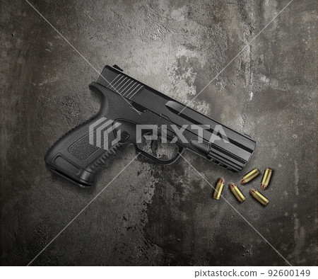 Bullets and pistols on cement floor Bullets and pistols on cement floor 92600149