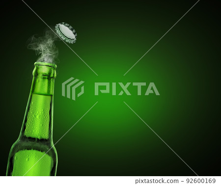 cold wet open beer bottle with smoke on green background 92600169