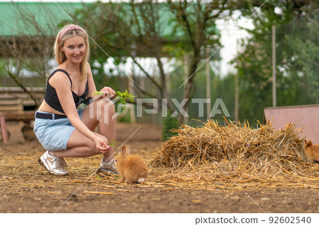 Girl brown feeds rabbit parsley easter bunny white nature garden, concept cute young from portrait and summer domestic, beautiful animal. Funny isolated, 92602540