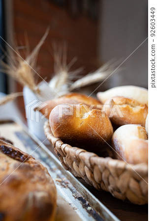 Ready-made La Ciriola romana bread on the counter at the artisan bakery. Vertical photo. 92603449