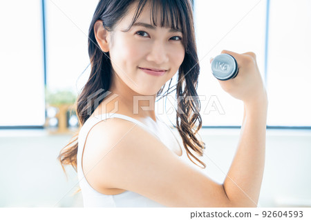 用啞鈴做肌肉訓練的年輕女子 92604593