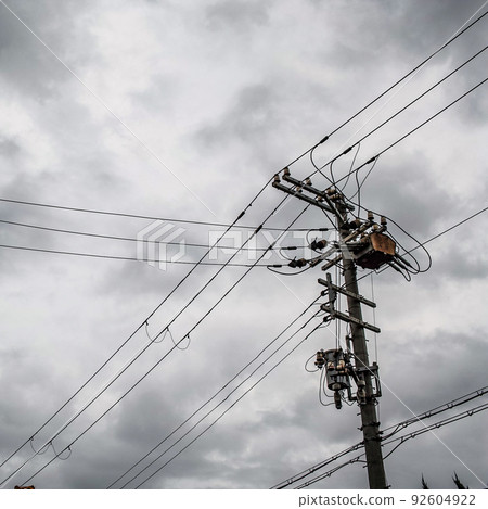 Silhouette of utility poles and electric wires in a cloudy sky Silhouette of utility poles and electric wires in a cloudy sky 92604922