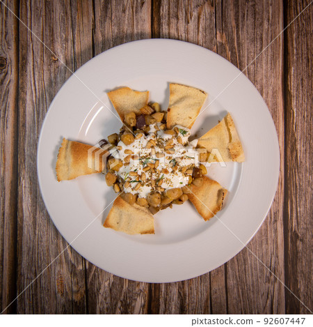 Oriental recipe aubergine and chickpea fatteh, pita, Greek yogurt, roasted pine nuts, zaatar Oriental recipe aubergine and chickpea fatteh, pita, Greek yogurt, roasted pine nuts, zaatar 92607447