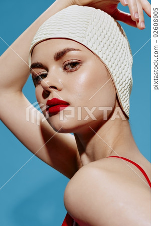 Conceptual art in retro style. A lady in a bathing cap looks arrogantly into the camera with her hand on her head 92608905