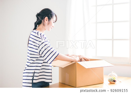 Women selling used clothing on flea market apps (packing) 92609155