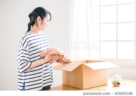 在跳蚤市場應用程序（包裝）上出售舊衣服的女性 92609196