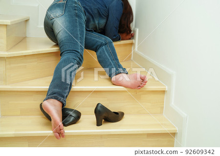 Asian business woman pain ankle, foot with leg cramp and fall down the stairs because slippery surfaces in office. 92609342