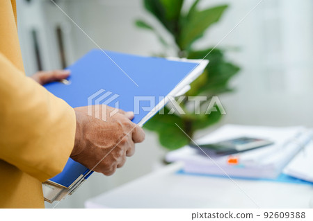 Businessman working and prepare paperwork report data to analysis information in file binder at office. 92609388