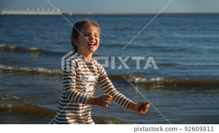 laughing girl of 4 years in dress happy on beach summer, selective focus laughing girl of 4 years in dress happy on beach summer, selective focus 92609811