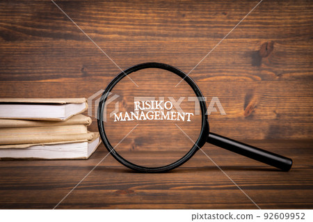 German word Risiko Management, risk management. Magnifying glass with text German word Risiko Management, risk management. Magnifying glass with text 92609952