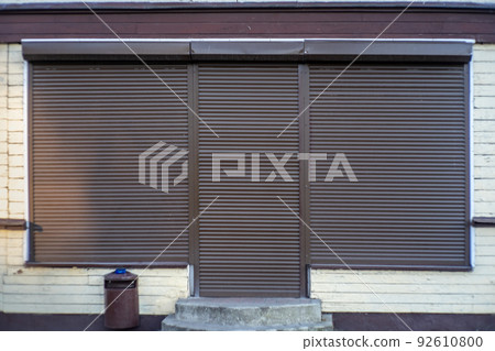 the shop window is closed with iron shutters. Bankrupt during the crisis. 92610800