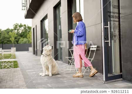 Woman with dog at cafe outdoors 92611211