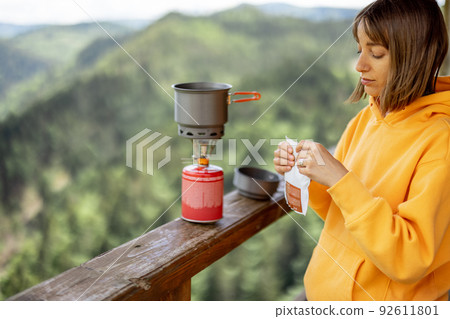 Woman prepares freeze-dried food for hiking in mountains Woman prepares freeze-dried food for hiking in mountains 92611801