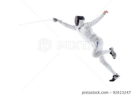 Dynamic portrait of young man, fencer in in fencing costume with sword in hand training isolated on white studio background. Sport, energy, skills Dynamic portrait of young man, fencer in in fencing costume with sword in hand training isolated on white studio background. Sport, energy, skills 92613247