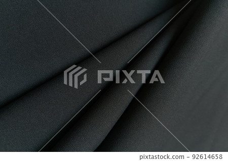 Gray crumpled or wavy fabric texture background. Abstract linen cloth soft waves. Gabardine wool fabric. Merino yarn. Smooth elegant luxury cloth texture. Concept for banner or advertisement. Gray crumpled or wavy fabric texture background. Abstract linen cloth soft waves. Gabardine wool fabric. Merino yarn. Smooth elegant luxury cloth texture. Concept for banner or advertisement. 92614658