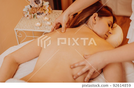 Pretty young woman during body massage in the studio, relax time concept Pretty young woman during body massage in the studio, relax time concept 92614859