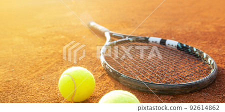 Close up of tenning racket and balls on the tennis clay ground or court, sport concept Close up of tenning racket and balls on the tennis clay ground or court, sport concept 92614862