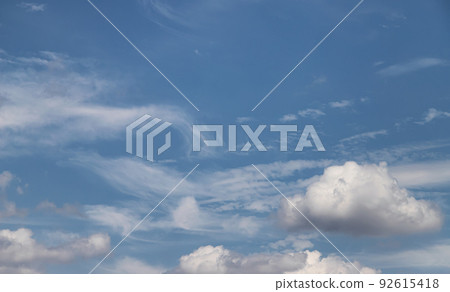 White fluffy clouds in a serene blue sky 92615418